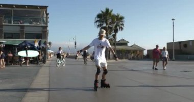 Hemosa Beach, CA USA - 12 Eylül 2021: Hermosa Beach 'te bisiklet yolunda genç bir adam paten kayıyor 