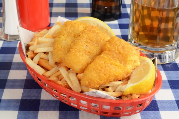 Peixe e batatas fritas embrulhados em jornal — Fotografia de Stock