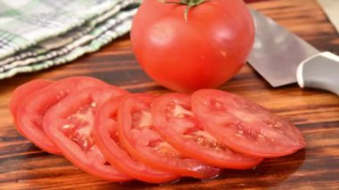Taze kırmızı domates dilimleri kesme tahtasından kayboluyor.