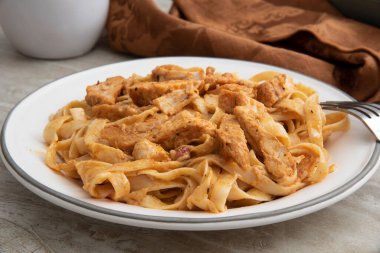 Fettuccine Alfredo ile karartılmış tavuk tabağı.