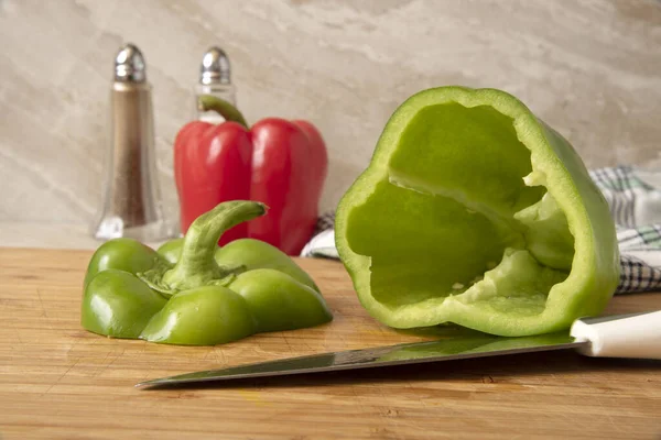 Green bell pepper with top and seeds removed for stuffed bell peppers on a cutting board