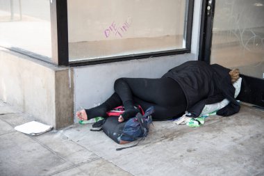 Los Angeles, CA USA - 12 Temmuz 2021: Boş bir perakende mağazasının önünde uyuyan evsiz kadın