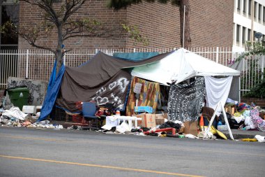 Los Angeles, CA USA - 28 Eylül 2021: Evsiz kampı ve şehirdeki bir ofis binasının yanındaki çöp yığınları