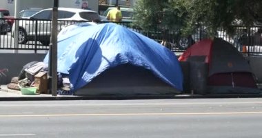 Los Angeles, CA USA - 24 Ağustos 2021: Bir marketin otoparkını çevreleyen kaldırımda evsiz kampı