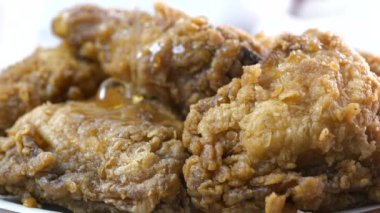 Bir tabak kızarmış tavuğun üzerine bal serpiştiren süper yavaş çekim