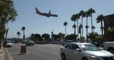 Los Angeles, CA USA - 21 Ağustos 2021: Ön planda COVID Test İstasyonu ile LAX Havaalanına iniş 