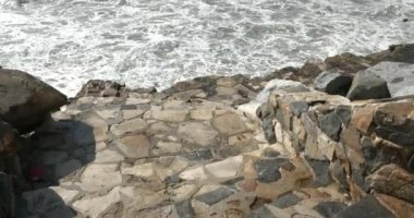 Aşağıdaki tropikal bir tatil köyündeki dalgalara giden merdivenler.