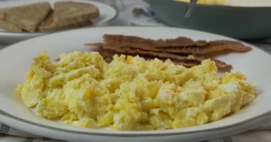 Bir çatal dolusu omlet, pastırma ve tost yemek.