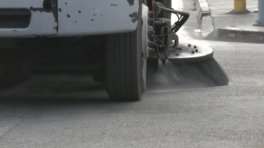 Yolu temizlerken bir sokak temizleyicisi yaklaşıyor.