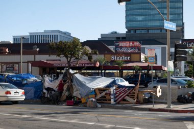 Los Angeles, CA USA - 14 Kasım 2021: Sizzler restoranının önündeki evsiz kampı ve Şükran Günü yemeği afişi 