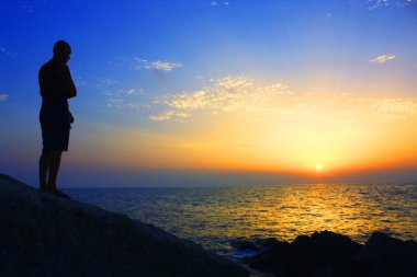 gün batımında Uçurumdaki adam