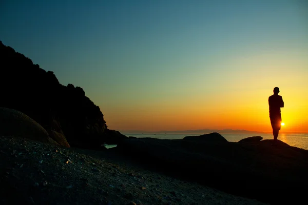 Man on the cliff at sunset — Stock Photo, Image