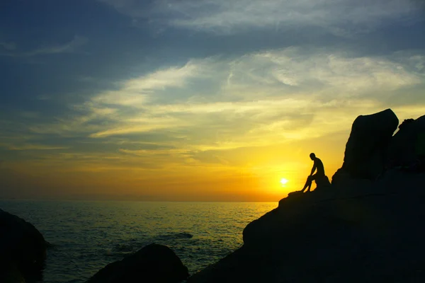 Ember a szikla, a naplemente — Stock Fotó