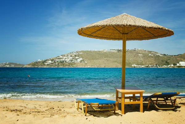 Ligbedden en parasols op mykonos strand — Stockfoto