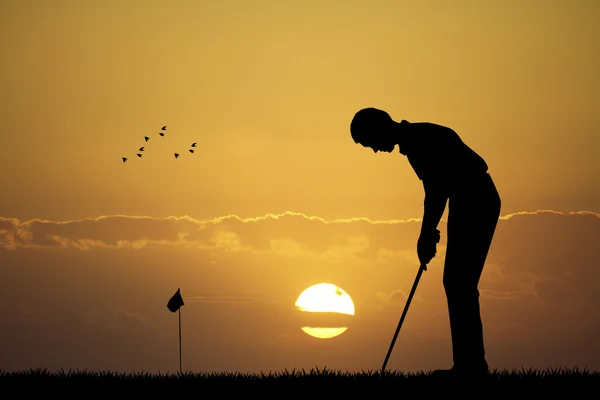 Homem jogando golfe ao pôr do sol — Fotografia de Stock