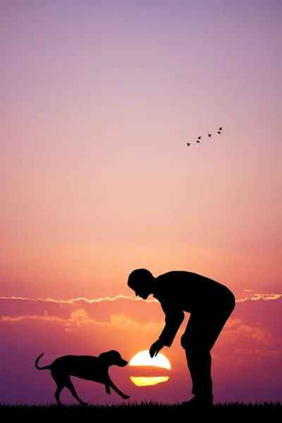 Homem com cão ao pôr-do-sol — Fotografia de Stock