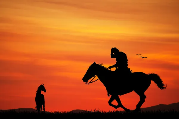 L'uomo cavalca al tramonto — Foto Stock