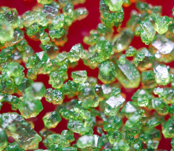Cristales verdes sobre fondo rojo. Primer plano extremo. Macro — Foto de Stock