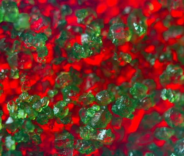 Cristales verdes sobre fondo rojo. Primer plano extremo. Macro —  Fotos de Stock