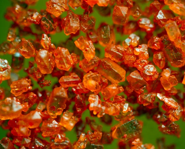 Orangefarbene Kristalle auf grünem Hintergrund. Extreme Nahaufnahme. Makro — Stockfoto