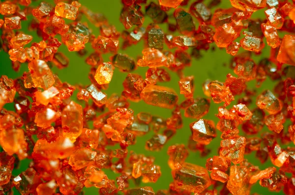 Orangefarbene Kristalle auf grünem Hintergrund. Extreme Nahaufnahme. Makro — Stockfoto