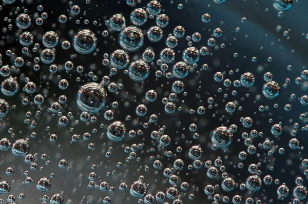 Vzduchové bubliny v kapalinu. abstraktní tmavé pozadí. makro — Stock fotografie