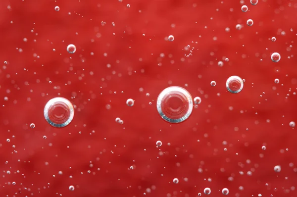 Luchtbellen in een vloeistof. Rode abstracte achtergrond. macro — Stockfoto