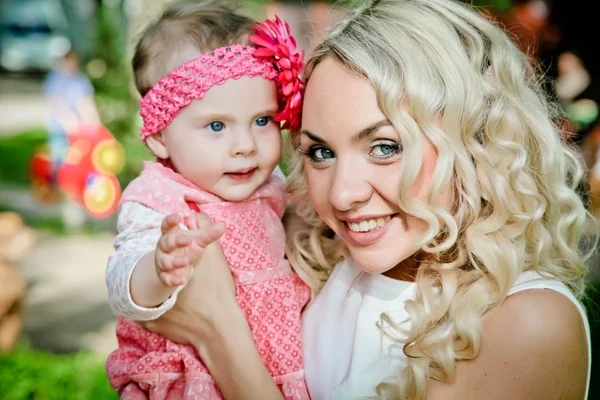 Porträtt av leende vacker ung kvinna och hennes lilla dotter — Stockfoto