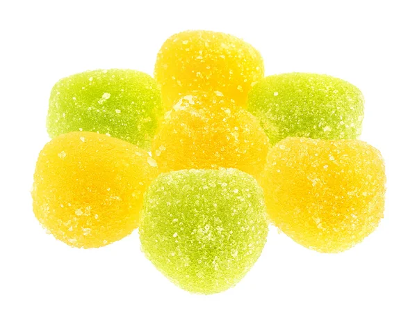 Eine Handvoll grüner und gelber Süßigkeiten in Nahaufnahme isoliert auf weißem Hintergrund. — Stockfoto