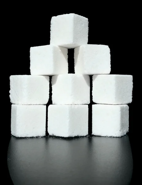 Heap pieces of sugar on a black background. — Stock Photo, Image