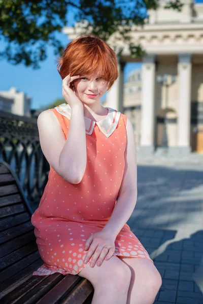 Menina Cabelos Vermelhos Bonita Vestido Rosa Curto Banco Parque Dia — Fotografia de Stock