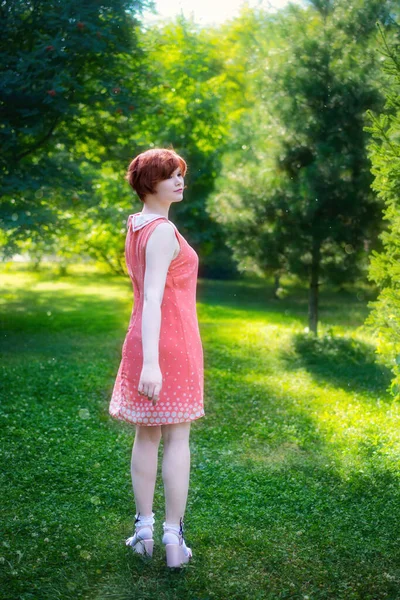 在夏日的公园里 一个阳光灿烂的日子里 一个红头发的女孩开怀大笑 — 图库照片