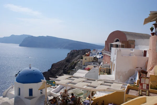 Old-style white traditional windmills in terraced village Oia of Cyclades island Santorini Greece on the blue Aegean Sea and sky background — Stock Photo, Image