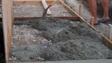 Çimentoyu karıştıran işçi. İnşaat havanı yapılıyor