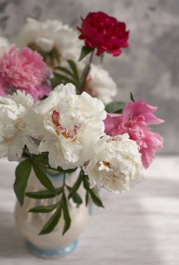 Beyaz ve pembe şakayıkların olduğu beyaz bir vazoda