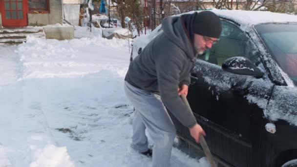 Чоловік Лопатою Розчищає Сніг Навколо Автомобіля Після Ночі Снігової Бурі — стокове відео