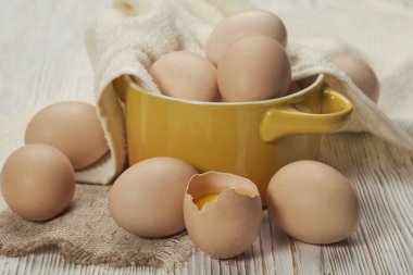 Ahşap zeminde bir kase çiğ tavuk yumurtası.