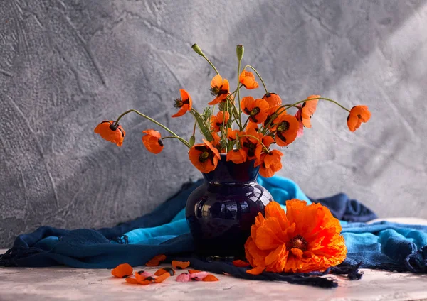 Mavi seramik vazoda kırmızı haşhaş buketi