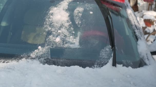 男が車から雪をクリアします。男は冬に路上で車から雪をクリア — ストック動画