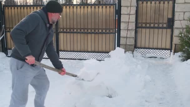 Hombre mayor quitando nieve del patio trasero — Vídeos de Stock