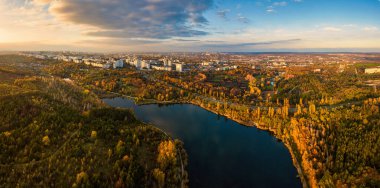 Sonbahar ağaçlarıyla dolu bir parktaki göl manzarası. Kishinev, Moldova. Suyun üzerinde destansı bir uçuş. Gündüzleri renkli sonbahar ağaçları.