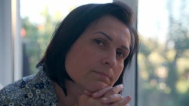 Ciddi bir kadın. Üzgün, düşünceli, genç, güzel bir kadın. Tereddüt ediyor..