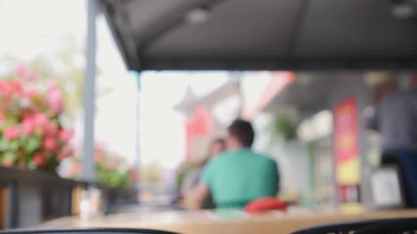Image floue ou client se déconcentrant dans un café extérieur. — Video