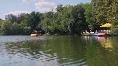 CHISINAU, MOLDOVA - 22 AĞUSTOS, 2021: Rose Valley Gölü 'nde mavi bir katamaran kullanan insanlar