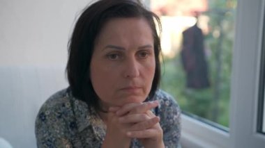 Ciddi bir kadın. Üzgün, düşünceli, genç, güzel bir kadın. Tereddüt ediyor..