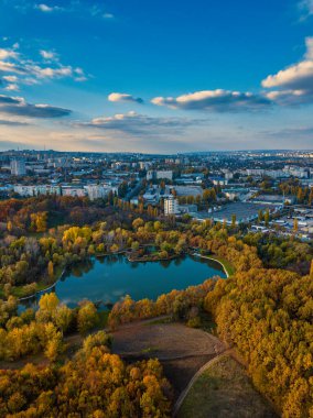 Sonbahar ağaçlarıyla dolu bir parktaki göl manzarası. Kishinev, Moldova. Suyun üzerinde destansı bir uçuş. Gündüzleri renkli sonbahar ağaçları.