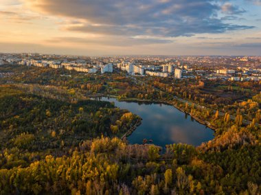 Sonbahar ağaçlarıyla dolu bir parktaki göl manzarası. Kishinev, Moldova. Suyun üzerinde destansı bir uçuş. Gündüzleri renkli sonbahar ağaçları.