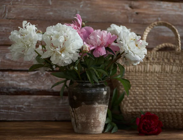 Nature morte avec pivoines blanches et roses dans un vieux vase en céramique sur fond en bois — Photo