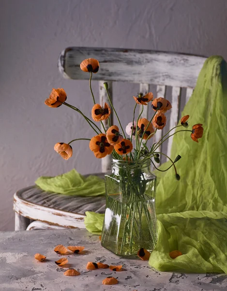 Klasik tarzda hazırlanmış küçük kırmızı gelincik buketi. Popies 'in klasik sandalyedeki vazoda durgun hayatı.