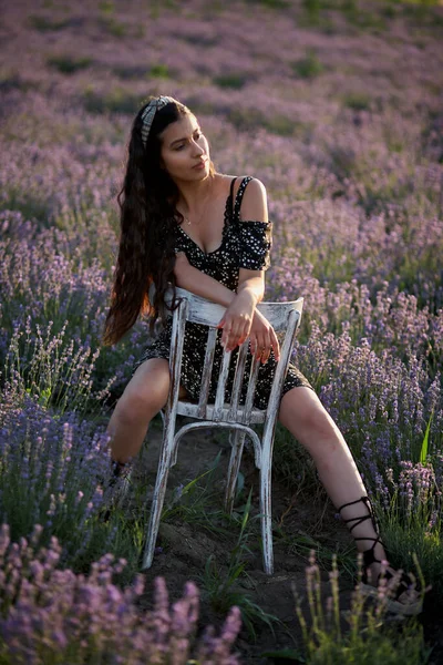 Όμορφο Κορίτσι Ένα Φόρεμα Bkack Κάθεται Μια Ξύλινη Καρέκλα Και — Φωτογραφία Αρχείου